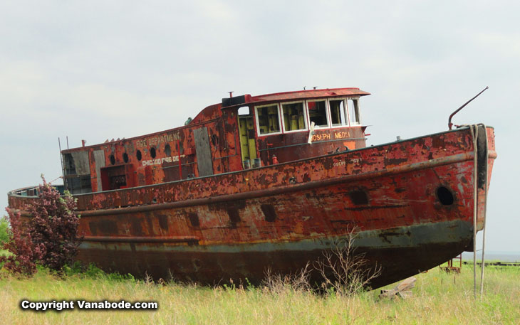 old red rusty ship dry docked on land in Michigan