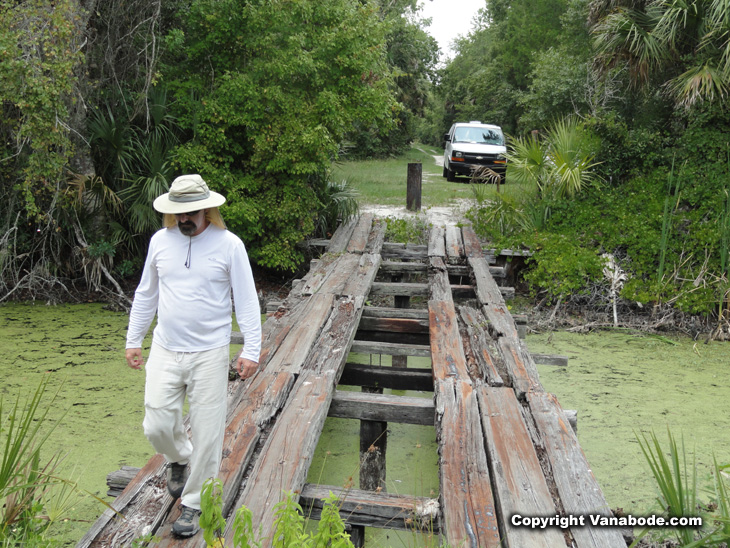 vanabode author jason odom crossing a footbridge in the tosohatchee wildlife management area of florida